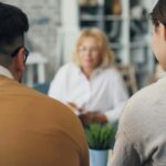 A couple sits together facing a therapist during a relationship counseling session, the therapist blurred in the background. Strengthen your ability to communicate honestly and openly with the guidance of relationship therapy in Los Angeles, CA.
