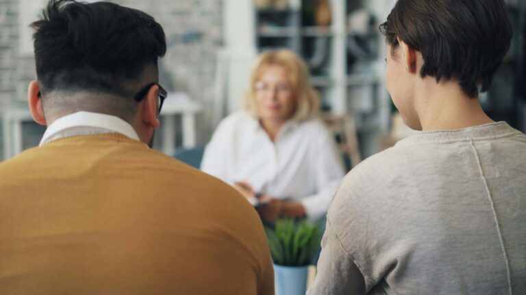 A couple sits together facing a therapist during a relationship counseling session, the therapist blurred in the background. Strengthen your ability to communicate honestly and openly with the guidance of relationship therapy in Los Angeles, CA.
