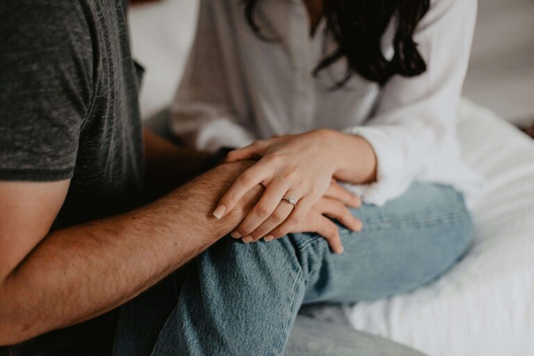 Close-up of couple's hands gently holding each other with engagement ring visible. Repair hurt and strengthen your connection through relationship therapy in Los Angeles, CA.