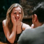 7 Signs You Need Relationship Therapy (Even If You’re Single) Woman laughing joyfully during conversation with person across from her at wooden table. Create healthier connections and genuine intimacy with relationship therapy in Los Angeles, CA.