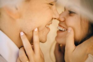 Close-up of couple smiling and touching faces intimately. Build the emotional safety that allows intimacy to flourish through relationship therapy in Los Angeles, CA.