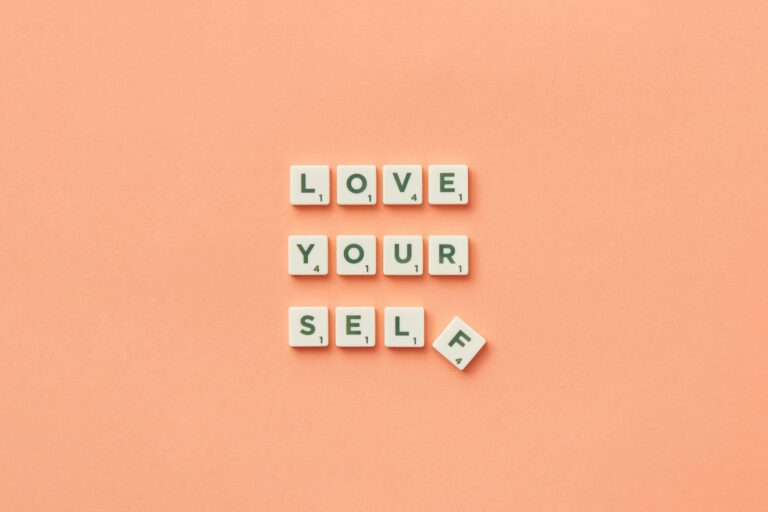 Scrabble tiles spelling out "love yourself" on peach background. Build the relationship with yourself that transforms how you love through relationship therapy in Los Angeles, CA.